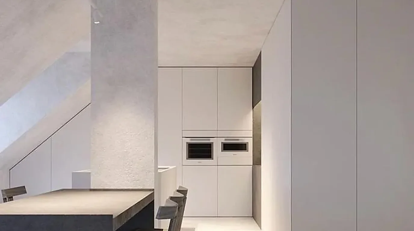 Cocina reformada de líneas minimalistas con isla y columnas de horno