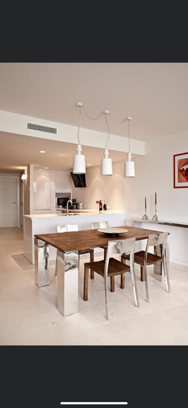 Cocina-comedor con mesa de madera y lámparas colgantes