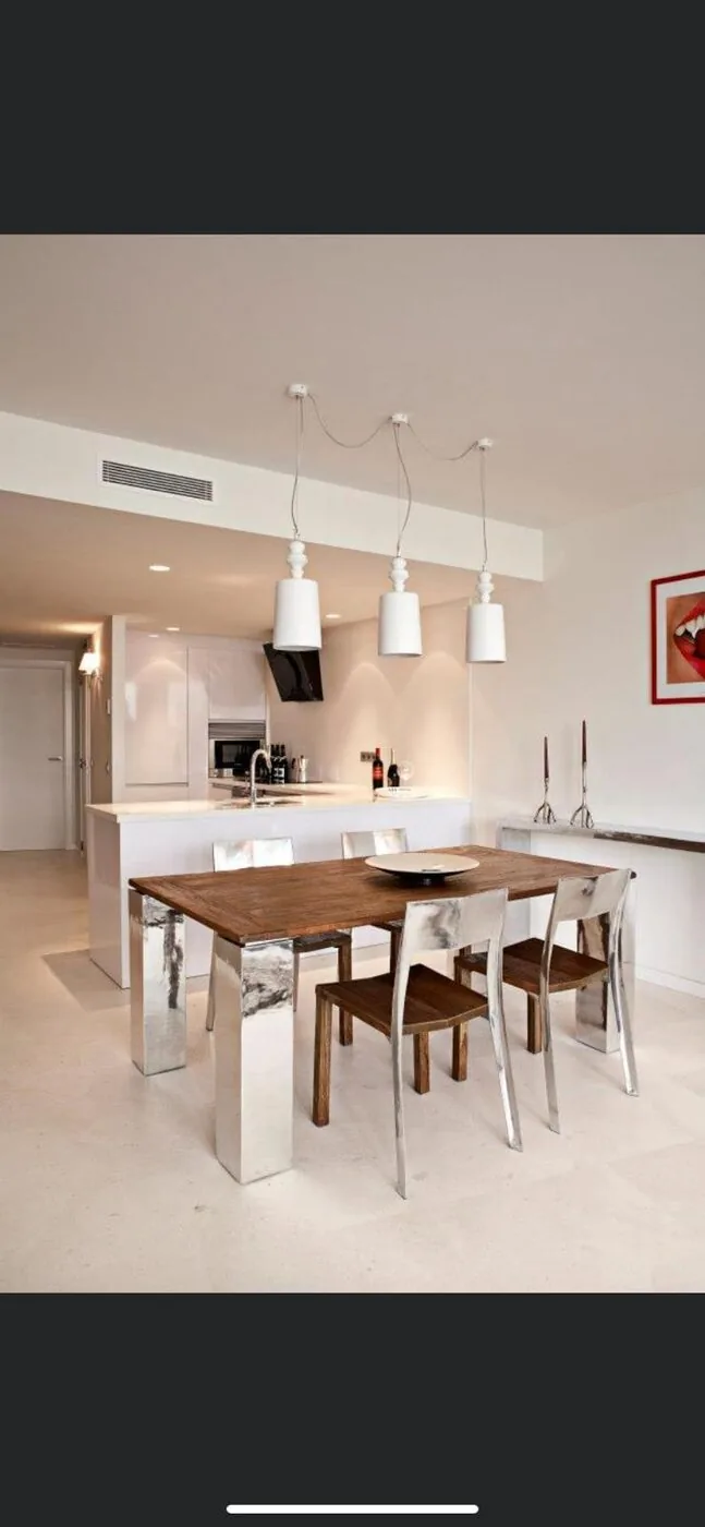Cocina-comedor con mesa de madera y lámparas colgantes